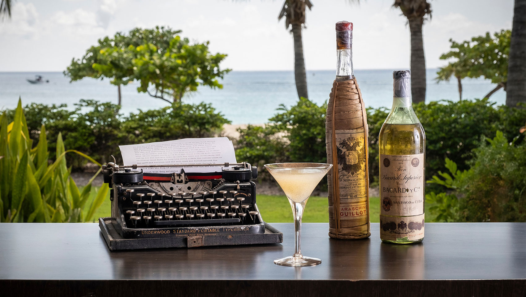 Cocktail + typewriter with ocean view