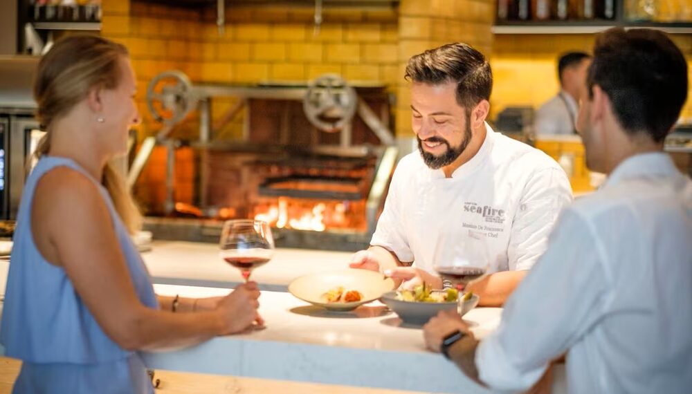 Chef preparing food in a warmly lit restaurant kitchen